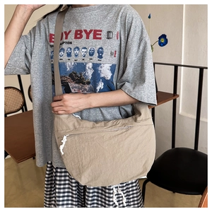 Close-up of beige crescent crossbody bag featuring durable nylon fabric and adjustable strap