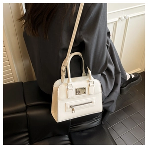 Detail of white Boston handbag with metal zipper and adjustable strap on a model