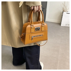 Detail of a ginger yellow Boston bag showing the leather texture and silver zipper detail