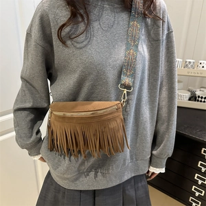 Brown suede tassel crossbody bag with bohemian woven strap and gold metal zipper detail