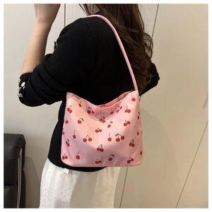 Close-up of pink nylon hobo bag featuring sweet cherry prints worn by a model