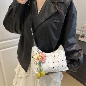 Modern white crossbody bag with black bow embroidery and floral charm detail