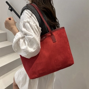 Minimalist red suede large tote bag with shoulder straps shown in a minimalist scene
