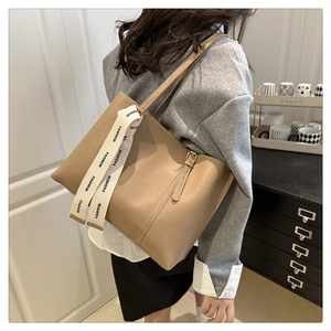 Dettaglio della borsa tote kaki con nastro alla moda e trama liscia in ecopelle di lusso
