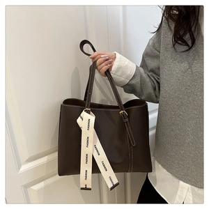 Dettaglio borsa shopper marrone con cuciture a contrasto e nastro decorativo Fashion