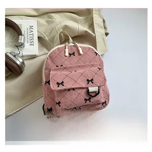 Close-up of pink corduroy mini backpack with bow embroidery and quilted texture