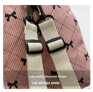 Detail view of pink corduroy backpack with bow pattern and adjustable shoulder straps