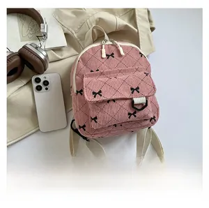 Detail of pink corduroy mini backpack with black bow embroidery and wide woven straps