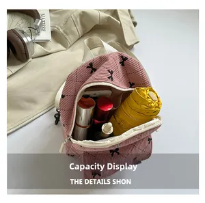 Pink corduroy backpack interior showing storage space for umbrella and cosmetics