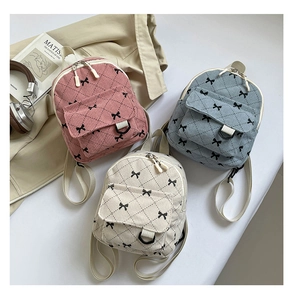 Three corduroy backpacks in pink, blue, and white with bows and quilted patterns