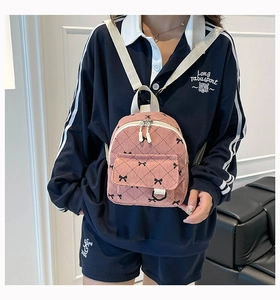 Pink corduroy mini backpack with bow detail and quilted pattern shown on model back