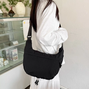 Large black nylon hobo shoulder bag with adjustable strap in a casual street style