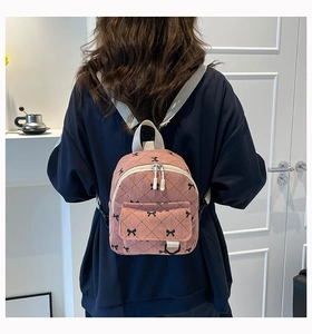 Rear view of a pink corduroy mini backpack featuring bow and diamond lattice patterns