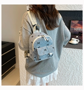 Detail of light blue corduroy mini backpack with bow prints and quilted stitching