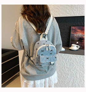 Detail of light blue corduroy mini backpack with bow embroidery and quilted pattern