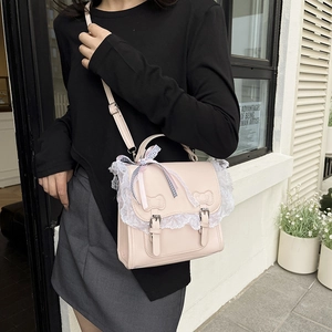 Sac bandoulière rose en cuir avec dentelle et nœud papillon porté en style urbain
