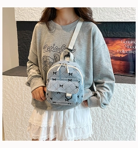 Detail of light blue corduroy mini backpack with bow pattern and quilted texture