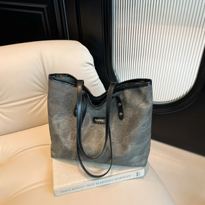 Elegante borsa tote in tela grigia con tracolle in pelle nera, stile moderno d'arte