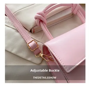 Detail of pink mini square bag with knotted handle and adjustable golden metal buckle