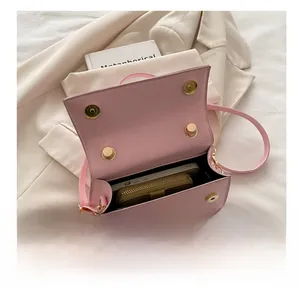 Pink minimalist crossbody bag capacity showing an iPhone and a brown zip wallet inside
