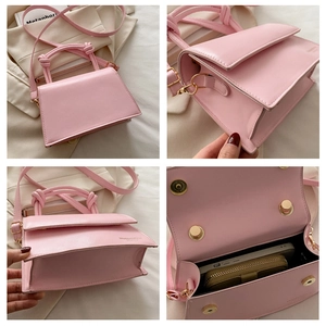 Detail of pink faux leather handbag with knotted handles and interior storage space