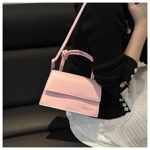 Close-up of pink rectangular crossbody bag featuring a unique knotted handle design