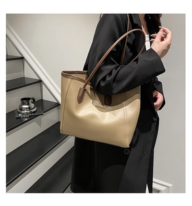 Detail of minimalist tote bag with khaki PU leather and dark brown shoulder straps