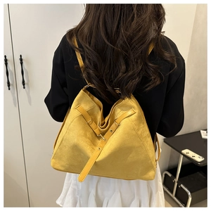 Detailed back view of a ginger yellow suede tote bag with metal ring accents