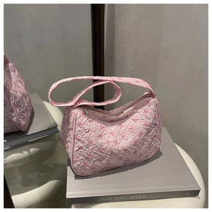 Detailed macro view of pink pleated hobo bag with floral bow patterns and smooth zipper
