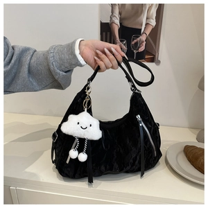Close-up of black pleated texture tote bag with silver zipper and white cloud plush charm