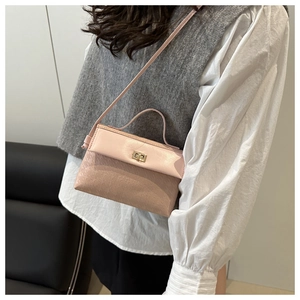 Pink crossbody Kelly bag with houndstooth embossing and gold twist lock on model