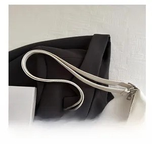 Detailed close-up of white PU leather handbag with wide shoulder strap and zipper closure