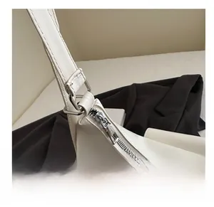 Detail of smooth silver metal zipper and precise stitching on the cream tote bag