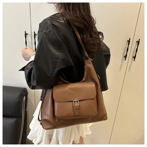 Dettaglio borsa tote marrone in ecopelle con texture opaca e tasca con patta metallica