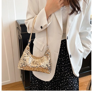Close-up of golden sequined shoulder bag styled with a white blazer and floral dress