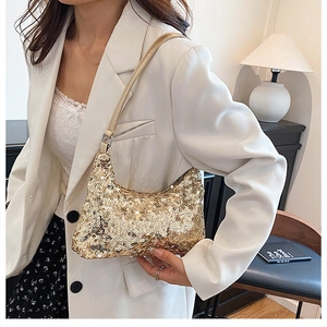 Detail of elegant gold sequin underarm bag with shimmering texture and leather strap