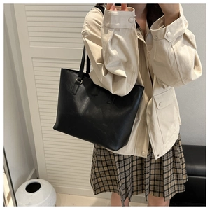 Classic black leather tote bag shown in a stylish commute lifestyle setting
