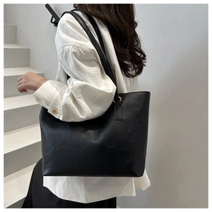Large capacity black shoulder bag made of glossy leather shown on model for daily commuting