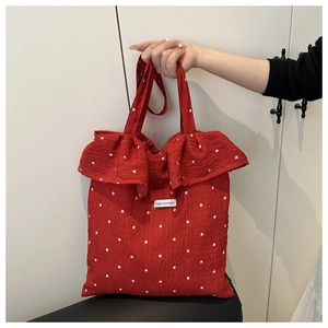 Dettaglio borsa a tracolla rossa in rete con fiori, volant e etichetta Magic Pocket
