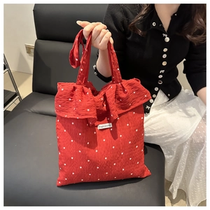 Dettaglio della borsa tote rossa a fiori con trama a pieghe e eleganti volant doppi