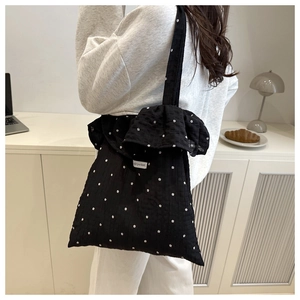 Dettaglio borsa in rete nera a fiori con bordi a volant ed etichetta le pocket applicata
