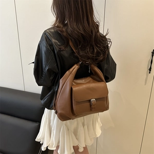Brown vintage leather tote bag with silver buckle flap pocket shown on a model