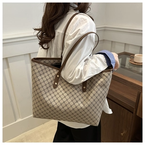 Detail of canvas tote bag with vintage pattern and brown leather trim on model