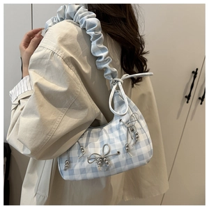 Detail of light blue checkered crescent bag with ruffled strap and ribbon bows