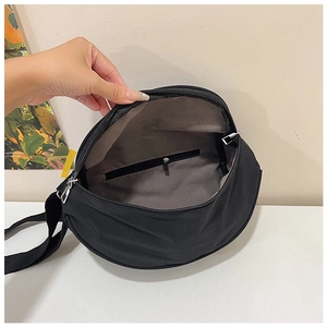 Detail of black crescent cross-body bag interior with zippered pocket and spacious lining