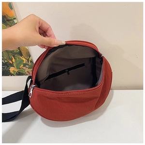 Detailed interior of the deep red crossbody bag showing a zipper pocket and large capacity