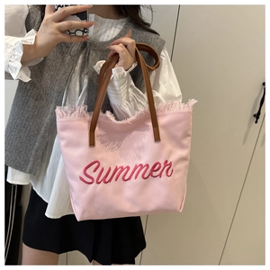 Détail du sac cabas en toile rose avec broderie Summer et bordure à franges