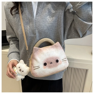 Close-up of cat-shaped plush crossbody bag with soft faux leather strap and kitten charm