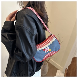 Gros plan d'un sac à bandoulière en denim avec carreaux rouges et dentelle sur un mannequin