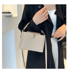 Detail of glitter handbag with gold metal V logo and detachable leather shoulder strap